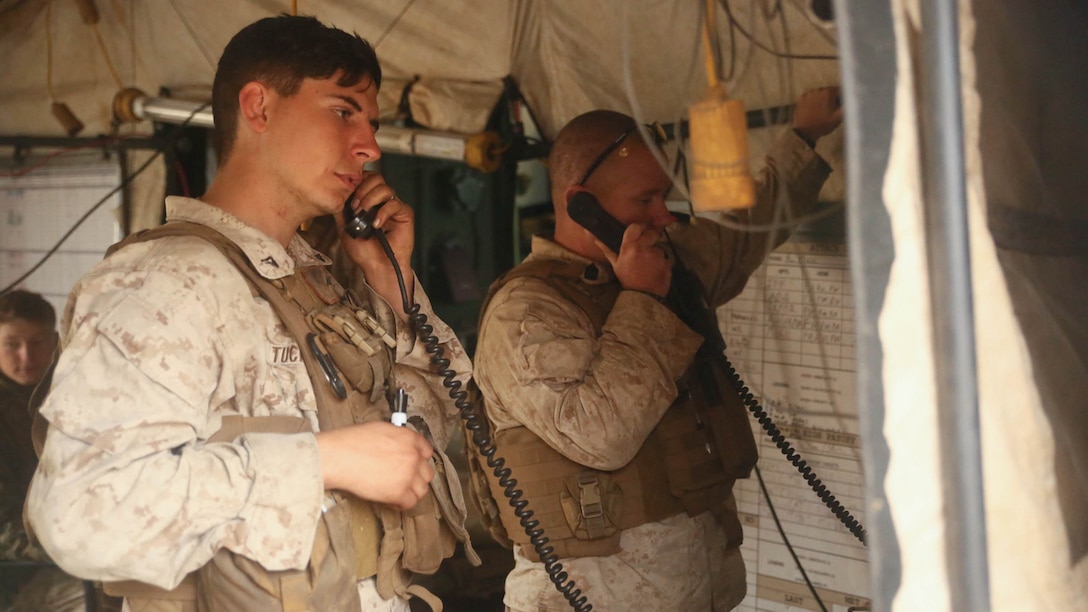 Lance Cpl. Andrew Tucker (left) and Master Sgt. Timothy Harvey coordinate artillery strikes with Bravo Battery over military radios from the Fire Direction Center March 8, 2015, during Operation Spartan Fury 15.2 at Pohakuloa Training Area. The military radios are referred to as the “hooks.”
