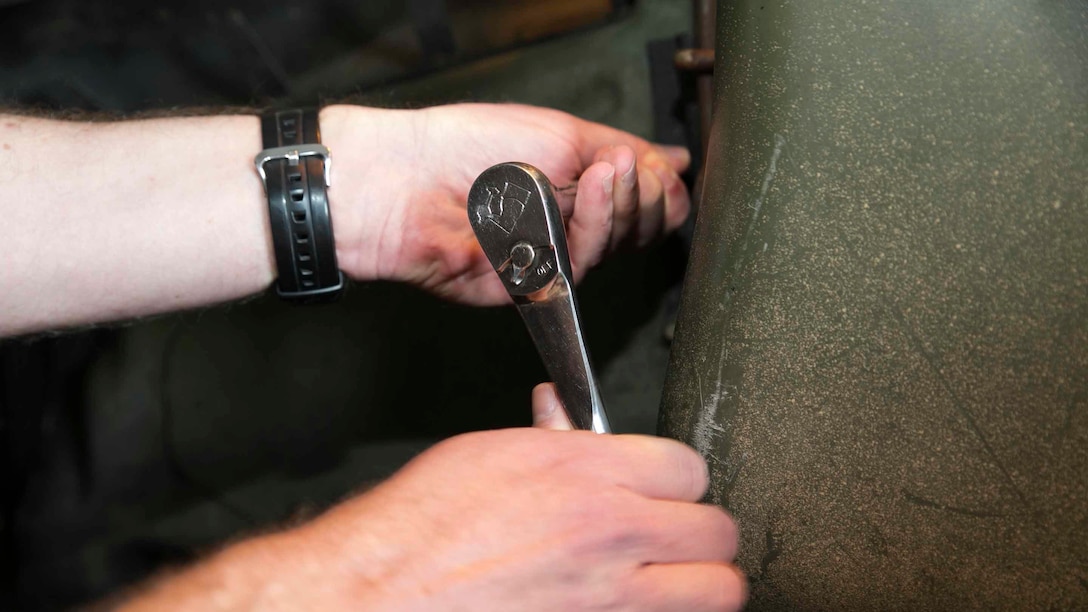Lt. Col. John C. Barry puts the final bolt in a Humvee to make Marine Air Control Squadron 4 100-percent equipment ready March 13 on Marine Corps Air Station Futenma. The final bolt in the Humvee made Marine Air Control Squadron 4 the only unit in the Marine Corps to be at 100 percent equipment readiness. MACS-4 has over 140 pieces of equipment they must maintain. Barry is the commanding officer of MACS-4, Marine Air Control Group 18, 1st Marine Aircraft Wing, III Marine Expeditionary Force.