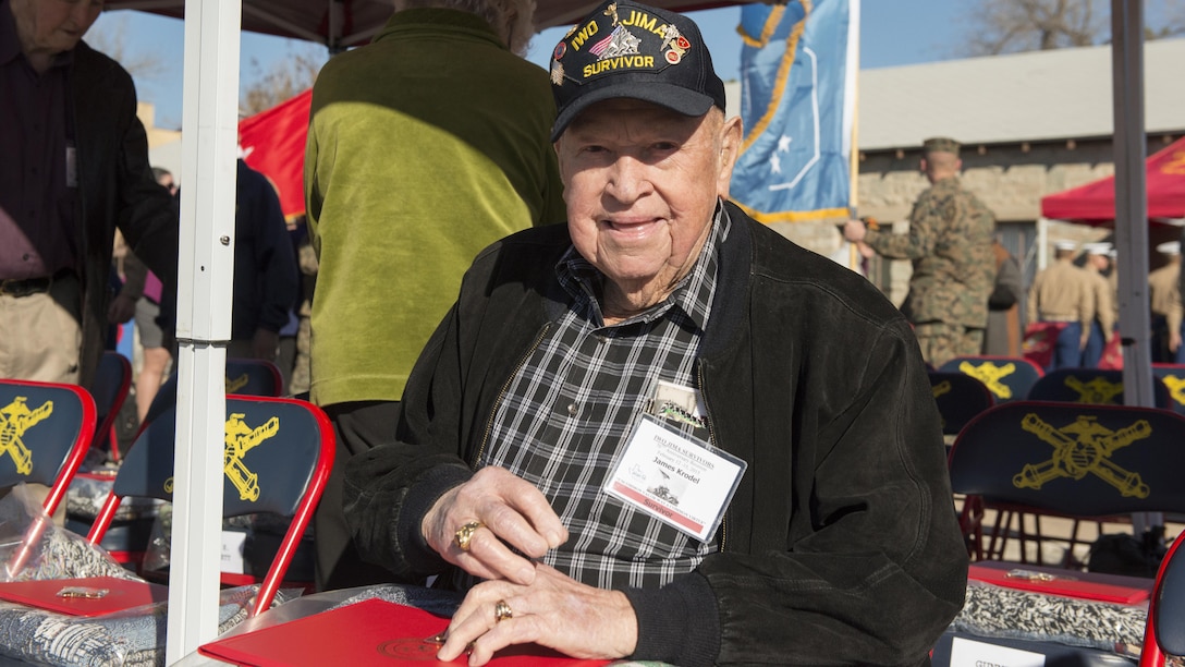 James Krodel, a Marine veteran of Guam and Iwo Jima from Quitman, Texas, smiles while looking at the gifts given to the Iwo Jima veterans before a ceremony conducted by the Marine Artillery Detachment at Fort Sill, Oklahoma, February 12, 2015. The Marine Artillery Detachment hosted veterans who fought in the battle of Iwo Jima during World War II by conducting a ceremony, providing a barbecue lunch and socializing with the Marines of the detachment.