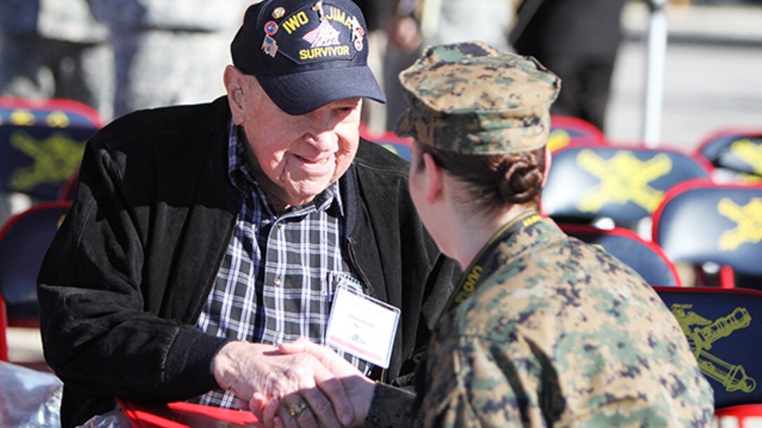 James "Jim" Krodel, a Marine veteran and survivor of the battle for Iwo Jima from Quitman, Texas, shakes hands with Sgt. Melissa Karnath, a combat correspondent stationed at Defense Media Activity, before a ceremony honoring survivors from the battle of Iwo Jima and their family members at Fort Sill, Oklahoma, February 12, 2015. Krodel served in the Marines 1944-1946.