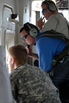 On board a Florida National Guard C-23 Sherpa airplane, Byran Schoonard (center) and Costas Katechis (top) from the Florida Fish and Wildlife Conservation Commission, join a Florida National Guard Soldier to scan the waters off of Destin, Fla., for signs of oil from the Deepwater Horizon oil spill, June, 22, 2010. Florida Army National Guard avators have been working closely with  Florida Fish and Wildlife by taking its specialists up for daily observation flights over the Gulf of Mexico