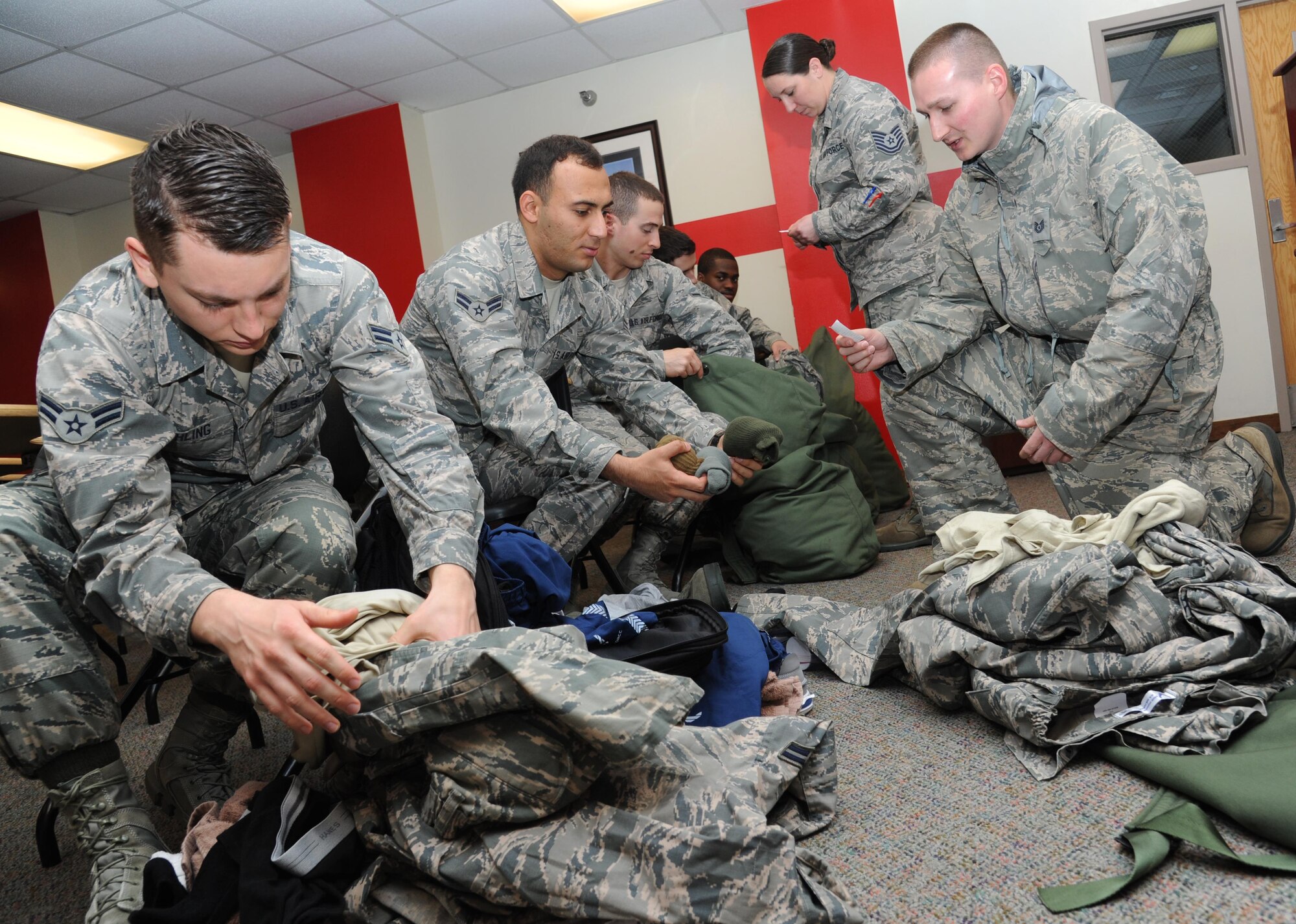 Airmen in the 335th Training Squadron are inspected for mandatory items during a bag drag inspection at the “Introduction to Mobility” training day for non-prior service Airmen at Davis Manor, Keesler Air Force Base, Mississippi, March 13, 2015. Airmen participated in pre-deployment training scenarios such as: going through a mobility processing line, administering self-aid and buddy care, reviewing the steps for wearing chemical warfare gear and receiving a pre-deployment briefing. The training was conducted to better prepare Keesler’s Airmen for deployment operations. (U.S. Air Force photo by Kemberly Groue)