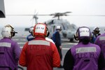 YOKOSUKA, Japan (March 14, 2015) Sailors from the damage control and refueling teams aboard the the U.S. 7th Fleet flagship USS Blue Ridge (LCC 19) observe an MH-60S Seahawk from Helicopter Sea Combat Squadron (HSC) 12 during flight operations. Blue Ridge resumed patrols to engage with regional partners throughout the U.S. 7th Fleet area of operations following a six-month ships restricted availability period. (U.S. Navy photo by Mass Communication Specialist 3rd Class Samuel Weldin/ RELEASED)