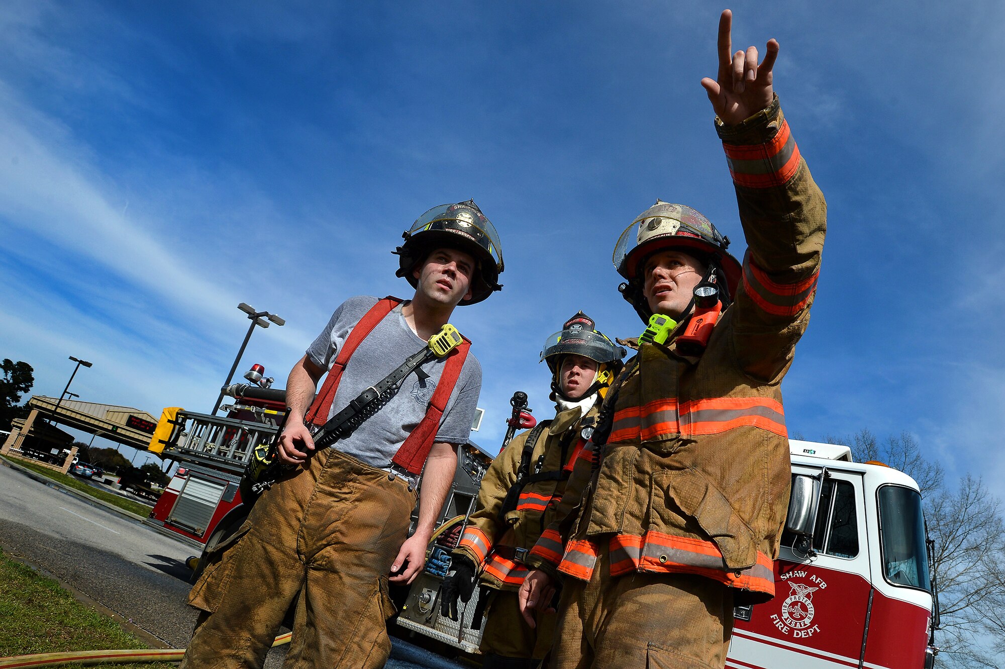 A U.S. Air Force Airmen assigned to the 20th Civil Engineer Squadron points to the location of a brush fire while communicating with other firefighters as they respond to the fire outside of Shaw’s main gate at Shaw Air Force Base, S.C., March 16, 2015. The fire department responded to a brush fire in which it took three minutes to arrive on scene (U.S. Air Force photo by Staff Sgt. Kenny Holston/Released)