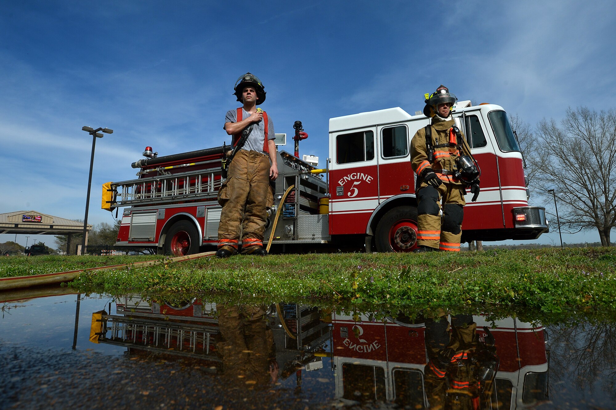 U.S. Air Force Airmen assigned to the 20th Civil Engineer Squadron look on while communicating with other firefighters as they respond to a brush fire outside of Shaw’s main gate at Shaw Air Force Base, S.C., March 16, 2015. The fire department responded to the fire in which it took three minutes to arrive on scene (U.S. Air Force photo by Staff Sgt. Kenny Holston/Released)