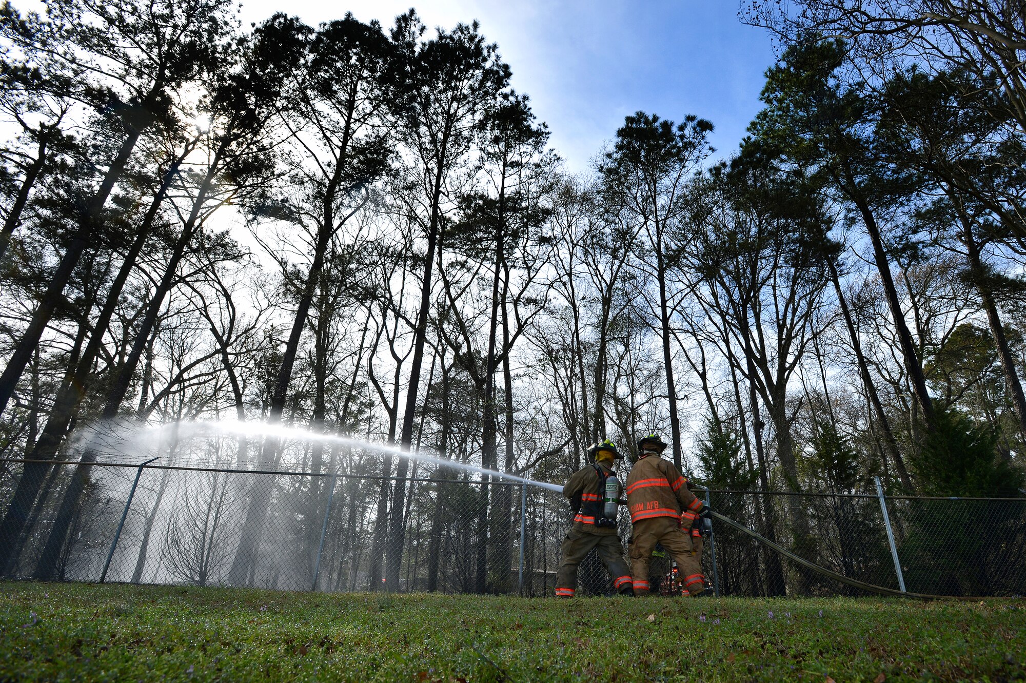 Two U.S. Air Force Airmen assigned to the 20th Civil Engineer Squadron fire department attempt to put out a brush fire just outside of the main gate at Shaw Air Force Base, S.C., March 16, 2015. The Airmen responded to assist the Sumter County Fire Department with the suppression of the fire. (U.S. Air Force photo by Staff Sgt. Kenny Holston/Released)