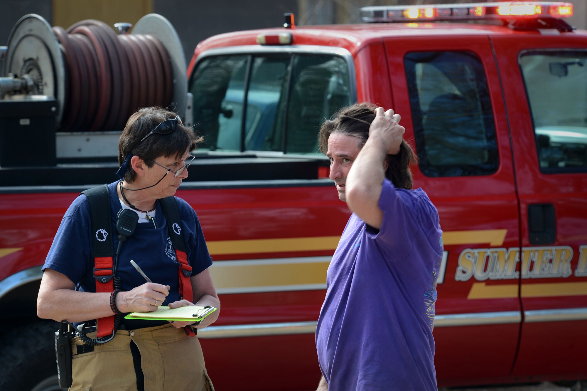 A Sumter County Fire Department firefighter writes the initial fire report on the scene of a brush fire just outside of the main gate at Shaw Air Force Base, S.C., March 16, 2015. 
Approximately 16 20th CES fire department Airmen along with the Sumter County Fire Department firefighters worked together to extinguish the fire. (U.S. Air Force photo by Senior Airman Jensen Stidham/Released) 
