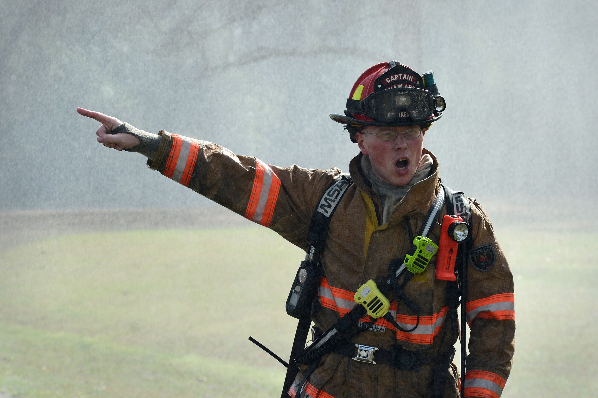 U.S. Air Force Tech. Sgt. Adam Gardner, 20th Civil Engineer Squadron firefighter, calls for additional help during a brush fire just outside the main gate at Shaw Air Force Base, S.C., Mar. 16, 2015. The 20th CES fire department responded to the fire within three-minutes of receiving the call, working with the Sumter County Fire Department to extinguish the fire. (U.S. Air Force photo by Senior Airman Jensen Stidham/Released) 