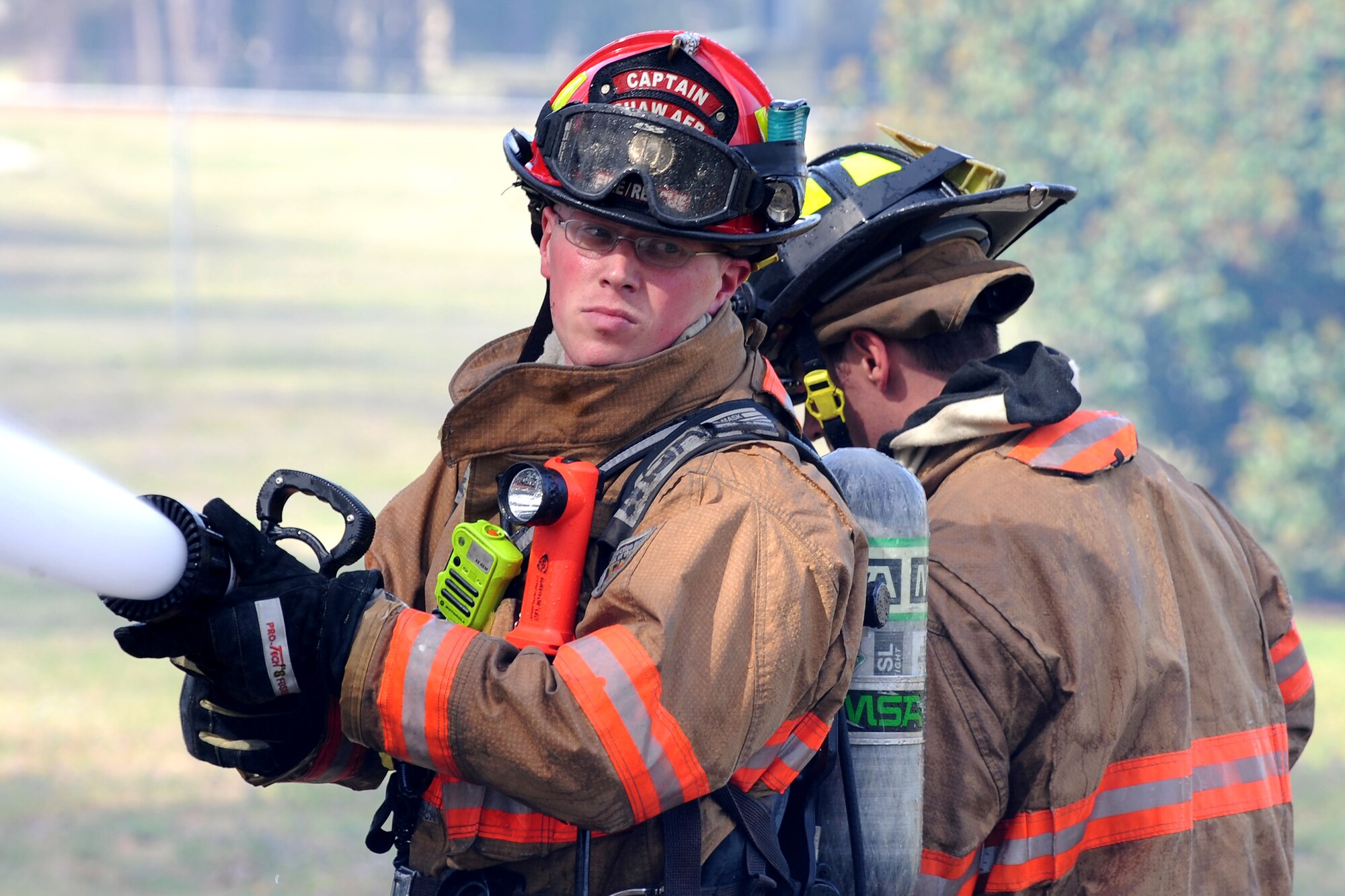 A U.S. Air Force Airman assigned to the 20th Civil Engineer Squadron fire department looks back while extinguishing a brush fire outside of the main gate at Shaw Air Force Base, S.C., March 16, 2015. Approximately 16 members of the Shaw fire department and the Sumter County Fire Department worked together to extinguish the fire. (U.S. Air Force photo by Airman 1st Class Michael Cossaboom/Released)