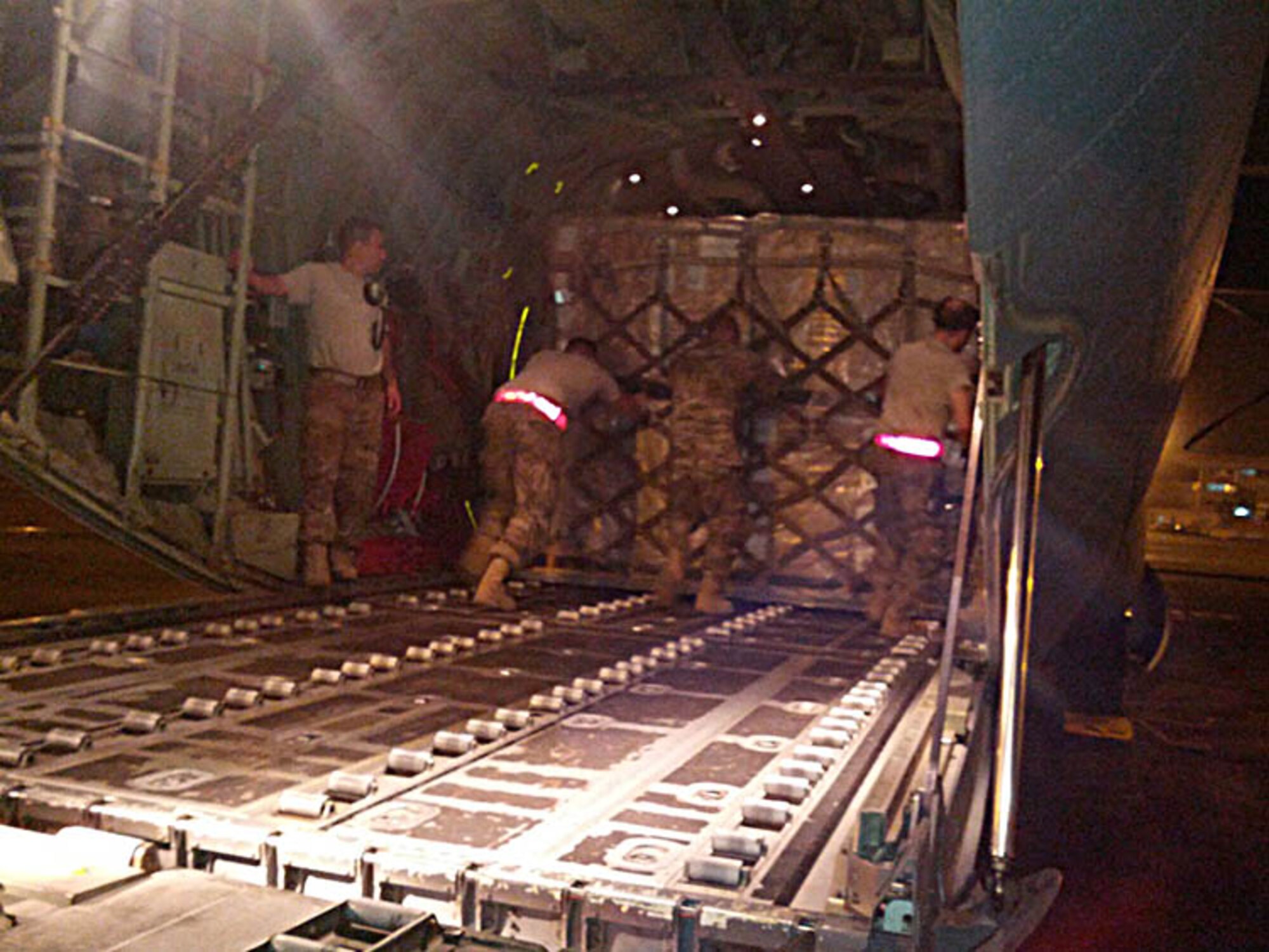 McChord aerial porters push pallets of cargo aboard a C-130 in Dakar, Senegal.  Airmen from the Reserve's 36th and 86th Aerial Port Squadrons, along with a couple of active-duty aerial porters, all from Joint Base Lewis-McChord, Washington, all returned from their deployment by the end of February.  The team of aerial port specialists had deployed in November 2014 in support of Operation United Assistance. (Courtesy photo) 