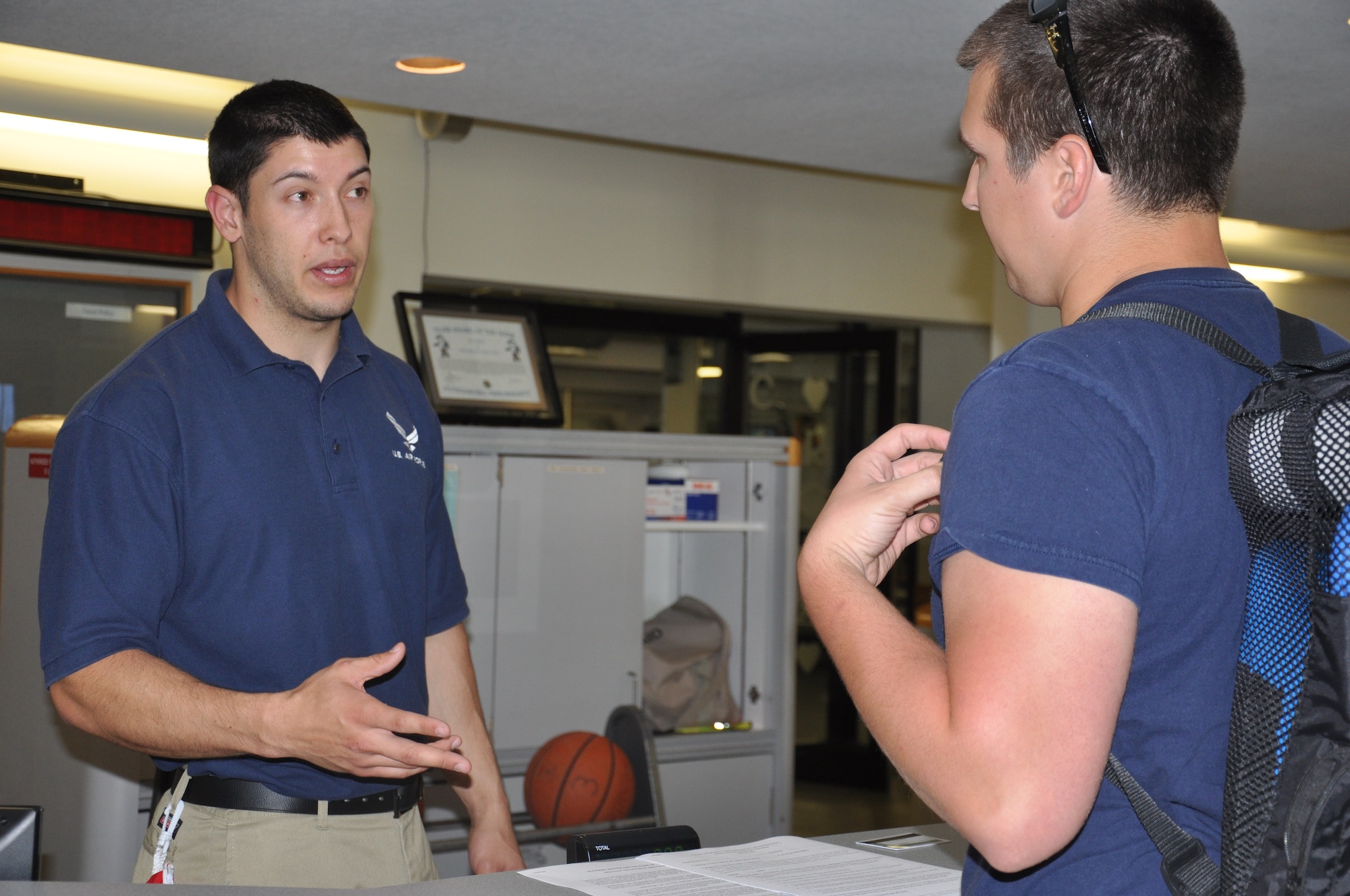 Senior Airman Jacob Palmer, Air Force Technical Applications Center Airman, briefs U.S. Coast Guard Petty Officer 2nd Class Michael Currence, Cutter Shrike, during registration, to gain 24/7 access to the Patrick Air Force Base Fitness Center, March 16, 2015. Fitness centers at PAFB and Cape Canaveral Air Force Station, Fla., are scheduled to remain accessible to active-duty military and DOD civilians beginning March 19, 2015. Only CAC holders who have registered with the fitness center for access during unmanned operations will have permission to use the fitness center during unmanned operations.  (U.S. Air Force photo/Heidi Hunt) (Released)