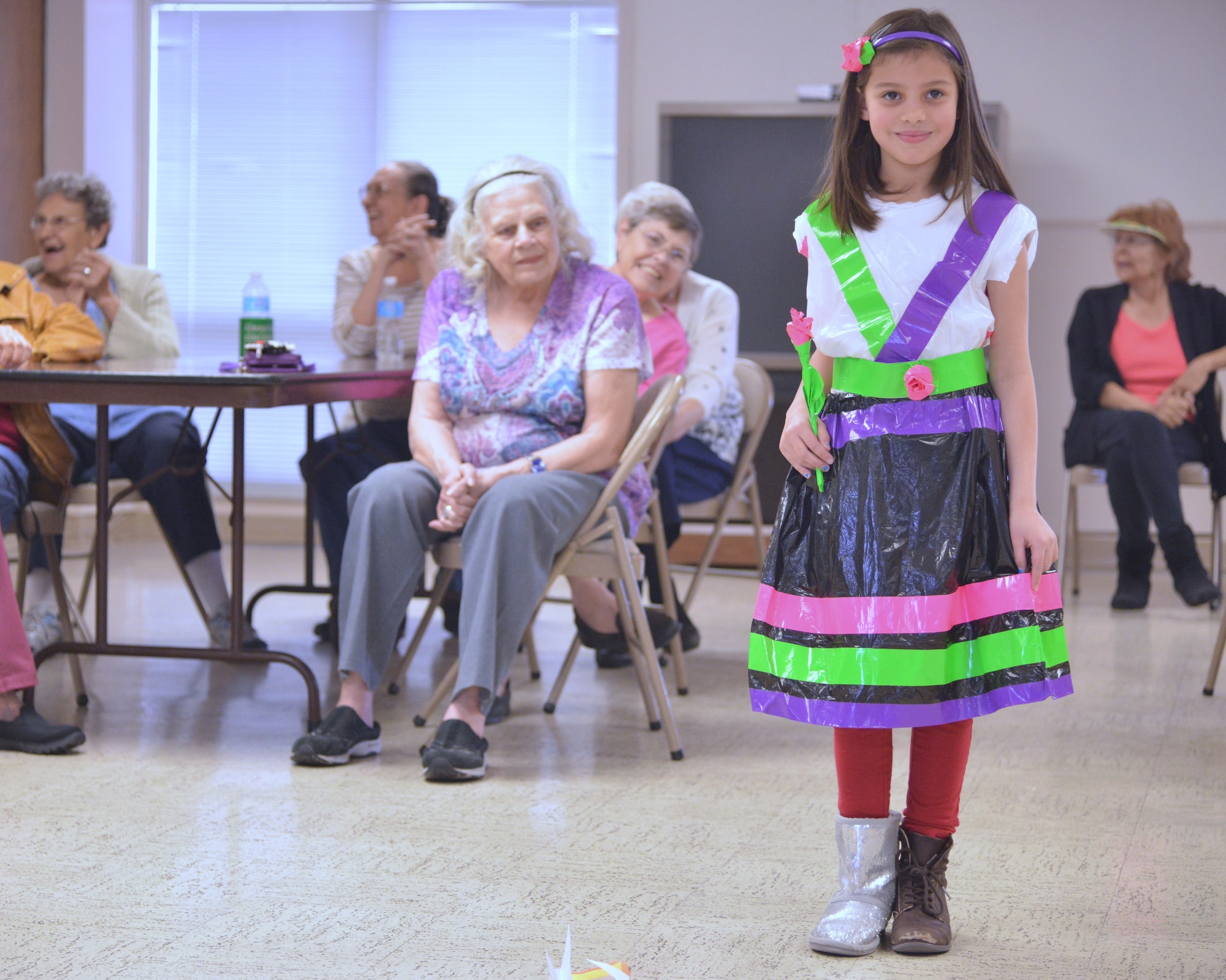 Emily Negron models her unique, recycled dress at a youth fashion show at Encino Gardens, an independent living apartment complex near Kirtland. Emily was one of about a dozen kids from Kirtland’s Youth Center who dropped by to show their styles and brighten the seniors’ day. (Photo by Todd Berenger)