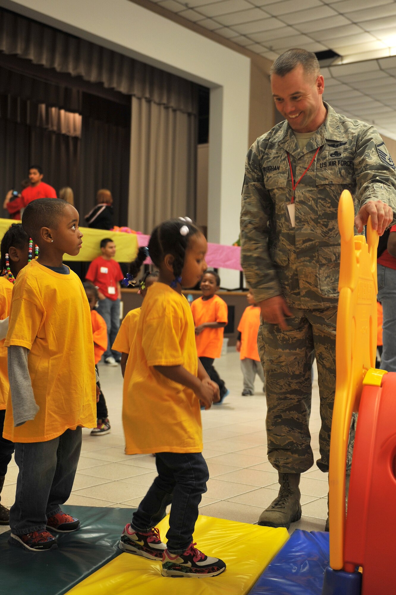 Master Sgt. Chris Vaughan, 22nd Aircraft Maintenance production supervisor, aides children at the beginning of an obstacle course during the 22nd Annual Green Eggs and Ham event at Beech Activity center March 11, 2015 in Wichita, Kan. Green Eggs and Ham is an event designed to get children excited about reading.  (U.S. Air Force photo by 2nd Lt. Krystal Jimenez)