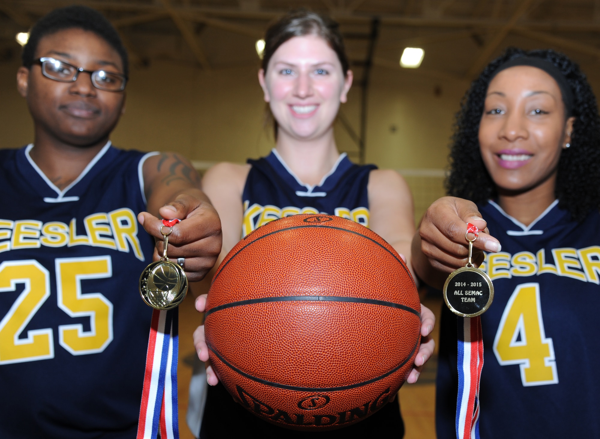 Staff Sgt. Kelsey Brown, 81st Surgical Operations Squadron women’s health administration technician, 2nd Lt. Teresa Koziol, 333rd Training Squadron cyber undergraduate student and Senior Master Sgt. Tomeika Frazier, 81st Force Support Squadron airman and family readiness center superintendent, hold medals awarded to them for making the 2014-2015 All Southeast Military Athletic Conference Team for women’s varsity basketball. Brown, Koziol and Frazier are members of the Keesler women’s varsity basketball team.  The Lady Dragons ended the season with a win/loss record of 4-3. Brown’s, small forward, season stats included 18 points, 12 rebounds and 5assists. Koziol’s, shooting guard and small forward, season stats included 15 points, 3 rebounds and 6 assists. Frazier’s, point guard, season stats included 14 points, 7 rebounds and 8 assists.  (U.S. Air Force photo by Kemberly Groue)