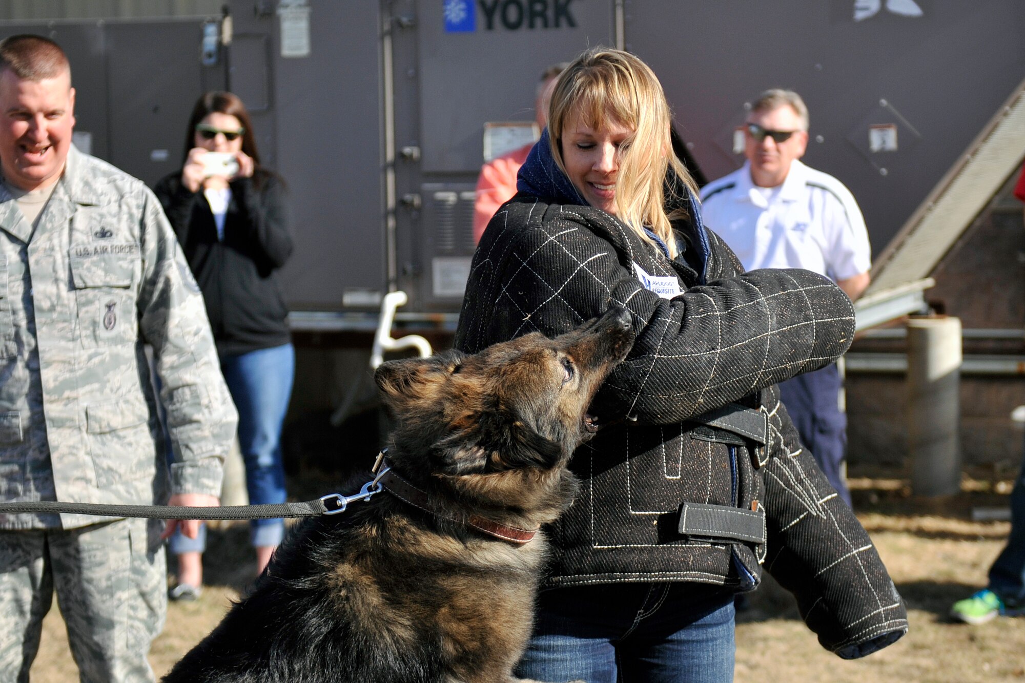 Kelly Jones, O’Gorman High School counselor, from Sioux Falls, S.D., receives a bite from a military working dog March 13 at Offutt Air Force Base, Neb. Several educators from the region received a K-9 demonstration from the 55th Security Forces Squadron as part of their base tour sponsored by the 343rd Recruiting Squadron. (U.S. Air Force photo by Jeff W. Gates/Released)