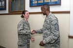 Chief Master Sgt. Troy Palmer, 12th Flying Training Wing command chief master sergeant, presents a coin to Senior Airman Kaitlyn Garcia, 502nd Security Forces and Logistics Support Group executive assistant, March 13 at Joint Base San Antonio-Randolph. Garcia was recognized in a surprise coining ceremony for going above and beyond to help restore Medal of Honor recipient Chief Master Sgt. Richard L. Etchberger’s photograph located at JBSA-Randolph’s Taj Mahal Hall of Valor dedicated to Medal of Honor recipients. (U.S. Air Force photo by Johnny Saldivar)
