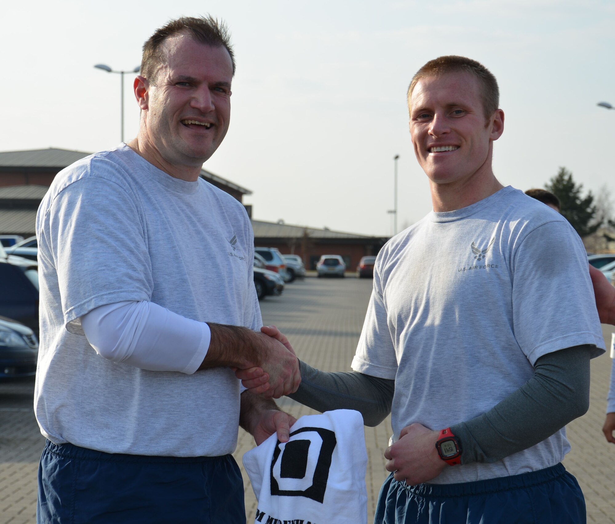 U.S. Air Force Col. Kenneth T. Bibb, Jr., left, 100th Air Refueling Wing commander, congratulates U.S. Air Force Capt. Justin Hauffe, right, 100th Operations Support Squadron chief of current operations from Champaign, Ill., after Hauffe came in as the first male across the finish line in the monthly wing run March 13, 2015, near the Hardstand Fitness Center on RAF Mildenhall, England. Hauffe completed the run at 17 minutes, 45 seconds. (U.S. Air Force photo by Gina Randall/Released)