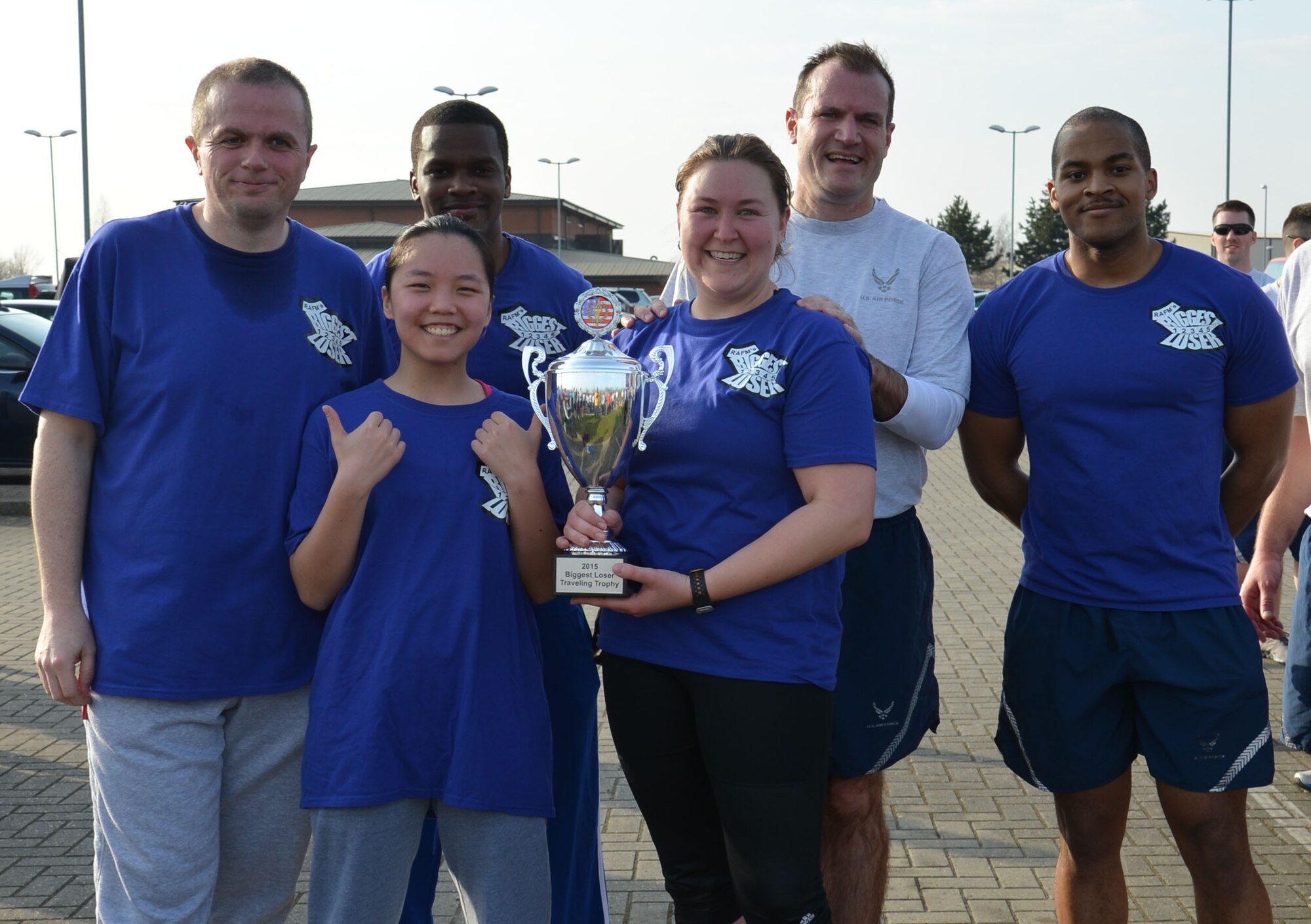 Members of the winning team in the “The Biggest Loser” competition receive their trophy from U.S. Air Force Col. Kenneth T. Bibb, Jr., second from right, 100th Air Refueling Wing commander, following the monthly wing run March 13, 2015, near the Hardstand Fitness Center on RAF Mildenhall, England. The blue team was this year’s winner in the six week competition where members were encouraged to reach a healthy target weight. (U.S. Air Force photo by Gina Randall/Released)
