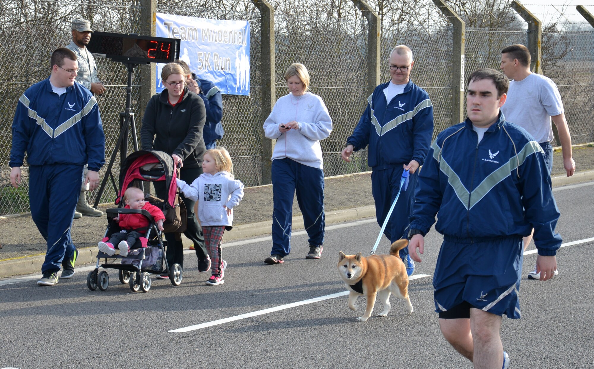 Team Mildenhall members, their families and pets participate in the monthly wing run March 13, 2015, near the Hardstand Fitness Center on RAF Mildenhall, England. The run is mandatory for all 100th Air Refueling Wing military personnel, but tenant units and base ID card holders of 13 years and older are welcome to attend. (U.S. Air Force photo by Gina Randall/Released)