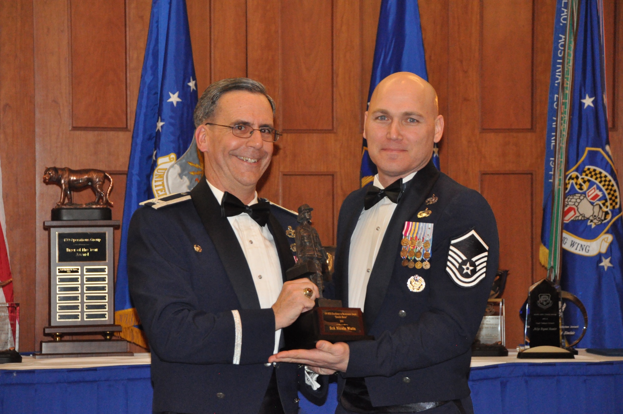 The 459th Maintenance Group commander, Col. Donald Robison, presents the 459 MXG Knuckle Buster Award to Master Sgt. Eugene St. Hillaire, 459th Aircraft Maintenance Squadron, who accepts on behalf of the winner, SrA Nicole Watts, 459th AMXS, at the 459 ARW Annual Awards Banquet on Saturday, March 7, 2015. (Air Force Photo / SrA Kristin Kurtz)
