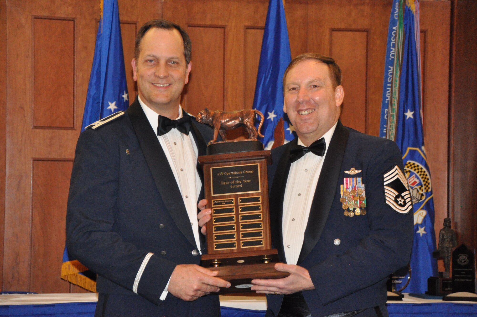 Chief Master Sgt. Rocky Rollins accepts the 459th Operations Group Tiger Award on behalf of  its winner, Technical Sgt. Christian McAlister, 756th Air Refueling Squadron. The Operations Group commander, Col. Michael Moeding, presented the award to him at the 459 ARW Annual Awards Banquet on Saturday, March 7, 2015. (Air Force Photo / SrA Kristin Kurtz)
