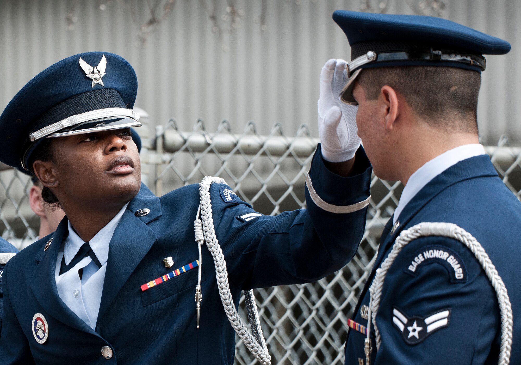 Airman 1st Class Suzanna Brown, 96th Medical Operations Squadron, makes last minute adjustments to an Airman’s cap prior to an Honor Guard graduation ceremony March 4 at Eglin Air Force Base, Fla. Approximately 12 new Airmen graduated from the 80-plus-hour course. The graduation performance includes flag detail, rifle volley, pall bearers and bugler for friends, family and unit commanders. (U.S. Air Force photo/Samuel King Jr.)