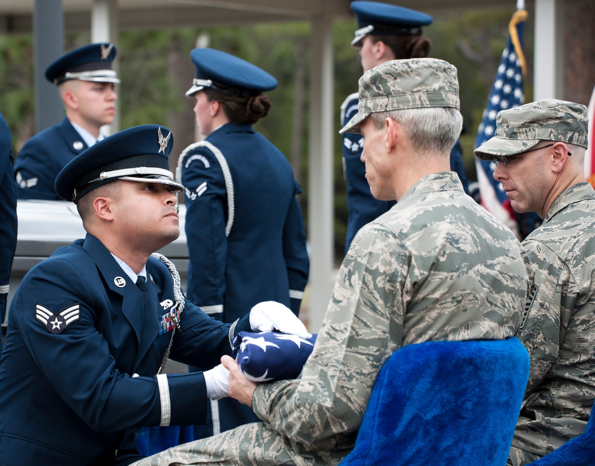 Senior Airman Jonathan Rivera-Flores, 33rd Maintenance Group, presents the flag to Col. Monte Cannon, 96th Test Wing vice commander, at the Honor Guard graduation ceremony March 4 at Eglin Air Force Base, Fla. Approximately 12 new Airmen graduated from the 80-plus-hour course. The graduation performance includes flag detail, rifle volley, pall bearers and bugler for friends, family and unit commanders. (U.S. Air Force photo/Samuel King Jr.)