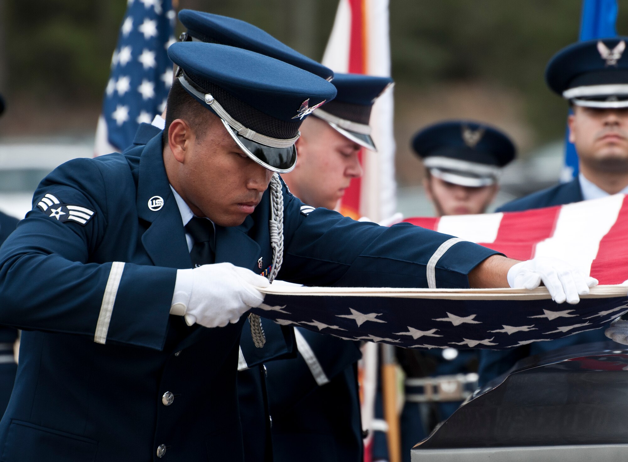 Senior Airman Joshua Ancheta, 96th Surgical Operations Squadron, removes any wrinkles from the flag during an Honor Guard graduation ceremony March 4 at Eglin Air Force Base, Fla. Approximately 12 new Airmen graduated from the 80-plus-hour course. The graduation performance includes flag detail, rifle volley, pall bearers and bugler for friends, family and unit commanders. (U.S. Air Force photo/Samuel King Jr.)