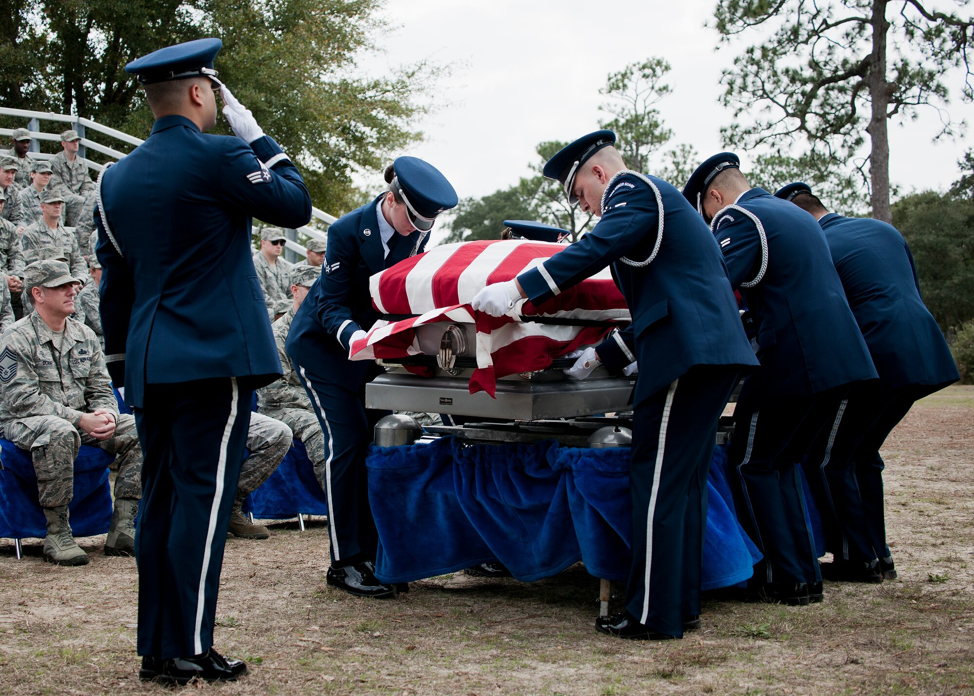 Senior Airman Jonathan Rivera-Flores, 33rd Maintenance Group, salutes as Honor Guard members set the casket down at their graduation ceremony March 4 at Eglin Air Force Base, Fla. Approximately 12 new Airmen graduated from the 80-plus-hour course. The graduation performance includes flag detail, rifle volley, pall bearers and bugler for friends, family and unit commanders. (U.S. Air Force photo/Samuel King Jr.)