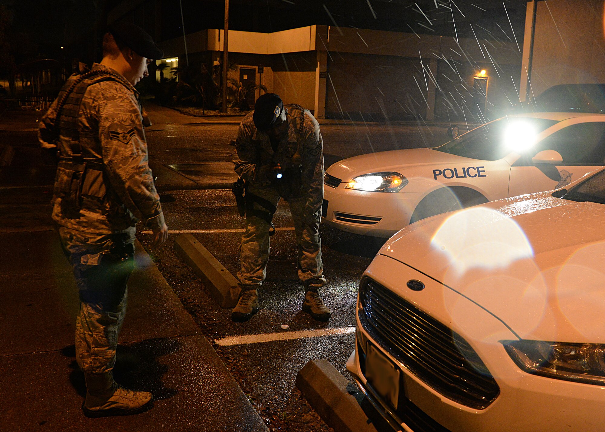 Airman 1st Class Jacob Alexander and Staff Sgt. Jason Moore, 81st Security Forces patrolmen, inspect a vehicle for scratches after a minor car accident March 12, 2015, Keesler Air Force Base, Miss. 81st SFS Airmen perform multiple roles to keep members of Keesler safe, ranging from identification checks at base entrances to searching for explosives and narcotics with military working dogs. (U.S. Air Force photo by Senior Airman Holly Mansfield)