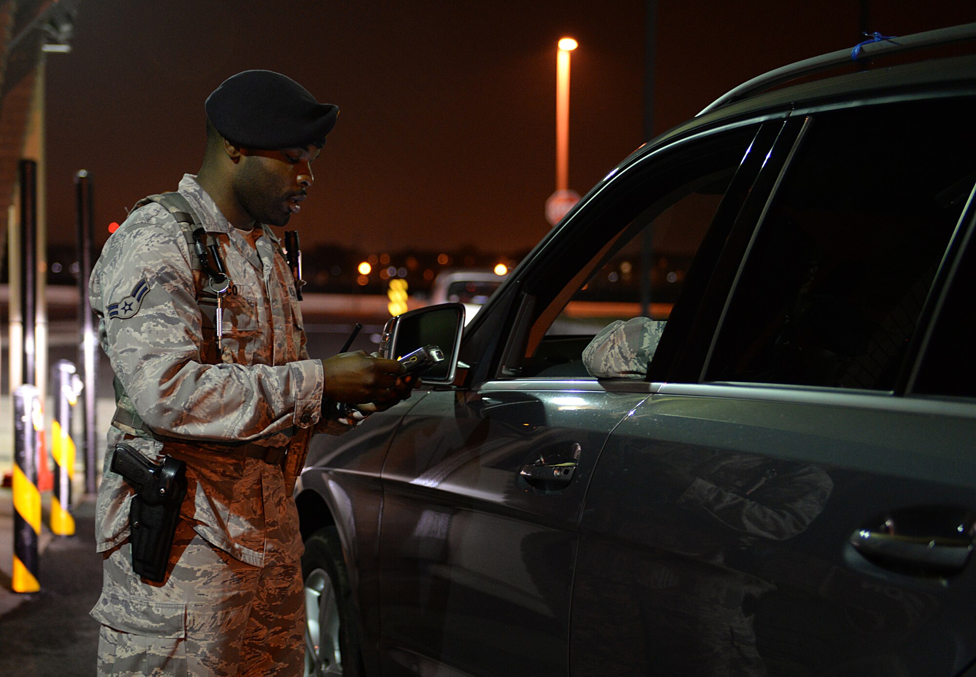 Airman 1st Class Darryl Glasco, 81st Security Forces entry controller, checks I.D. cards at a base entrance March 12, 2015, Keesler Air Force Base, Miss. 81st SFS Airmen perform multiple roles to keep members of Keesler safe, ranging from identification checks at base entrances to searching for explosives and narcotics with military working dogs. (U.S. Air Force photo by Senior Airman Holly Mansfield)