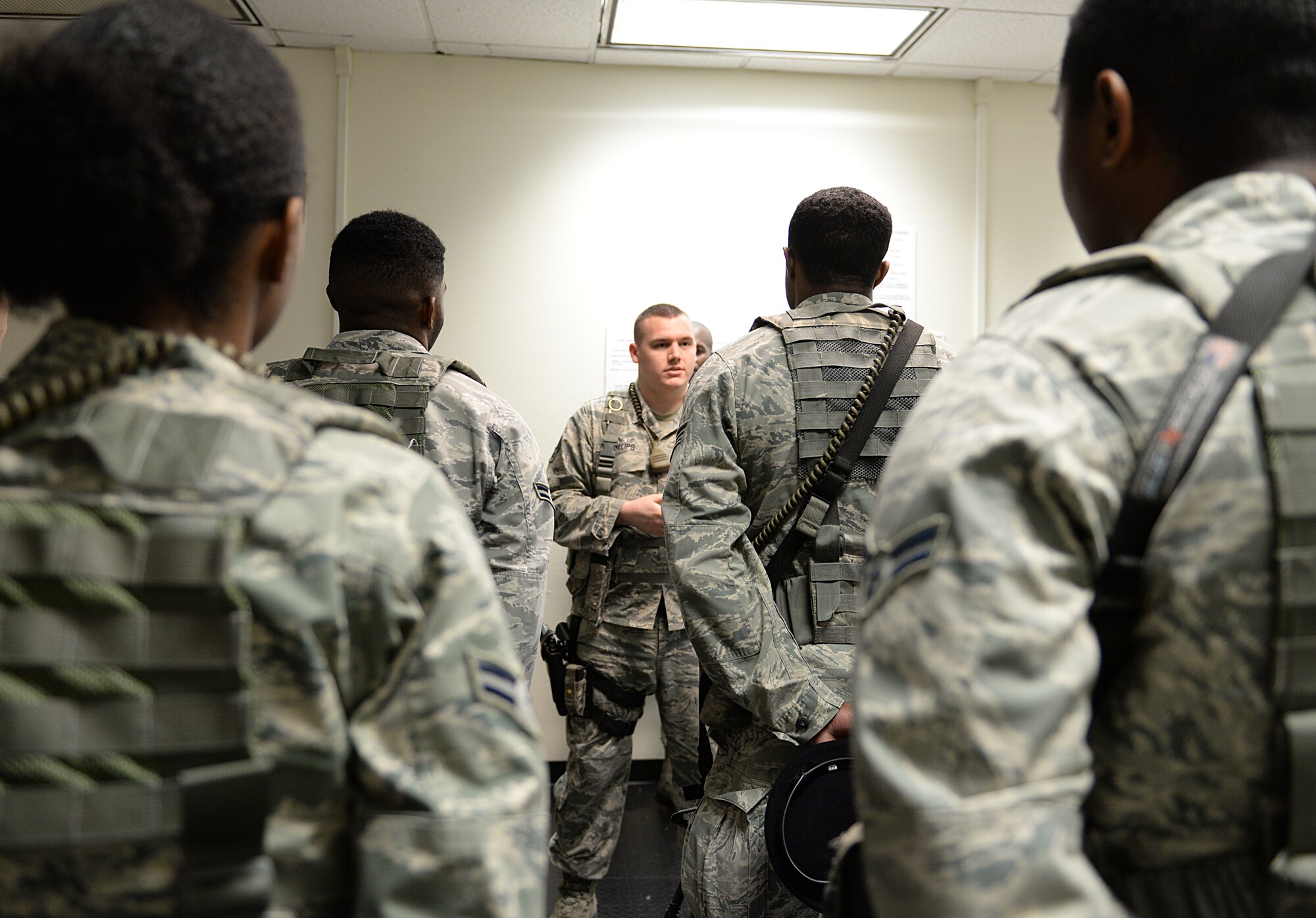 Airmen brief each other at the security forces night shift guard mount March 12, 2015, Keesler Air Force Base, Miss. Prior to starting their shifts, every flight holds  guard mount where accountability, daily messages and safety briefings are conducted. 81st SFS Airmen perform multiple roles to keep members of Keesler safe, ranging from identification checks at base entrances to searching for explosives and narcotics with military working dogs. (U.S. Air Force photo by Senior Airman Holly Mansfield)