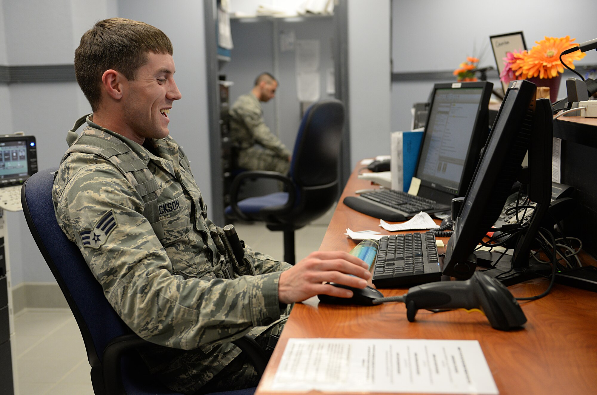 Senior Airman Danny Jackson, pass and identification shift supervisor, issues a temporary pass for a visitor March 12, 2015, Keesler Air Force Base, Miss. 81st SFS Airmen perform multiple roles to keep members of Keesler safe, ranging from identification checks at base entrances to searching for explosives and narcotics with military working dogs. (U.S. Air Force photo by Senior Airman Holly Mansfield)