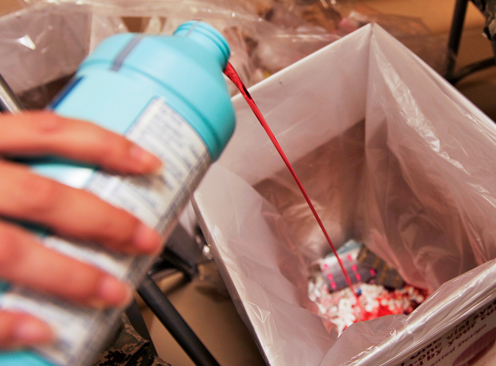 U.S. Air Force Senior Airman Mariah Alexander, 18th Medical Support Squadron pharmacy technician, pours expired medicine into a collection box during the Drug Take-Back Day event at the 18th Medical Group on Kadena Air Base, Japan, March 12, 2015. The 18th Medical Group conducts Drug Take-Back Day events at least twice each year. This year, the group received approximately 105 pounds of unused medications during the event. (U.S. Air Force photo by Naoto Anazawa)