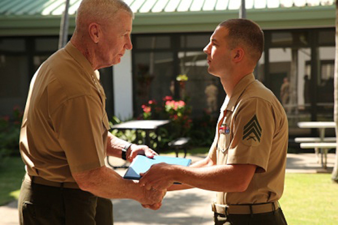 Marine Corps Sgt. Michael Joseph, right, avionics technician with Marine Light Attack Helicopter Squadron 367, receives the Emergency Cardiovascular Care Heart Saver Hero Award from U.S. Marine Corps Forces Pacific Commander Lt. Gen. John A. Toolan at a ceremony held at the Naval Health Clinic Hawaii aboard Joint Base Pearl Harbor-Hickam, March 13, 2015. The American Heart Association recognized Joseph for saving a fellow Marine suffering from a heart attack. Joseph performed CPR before paramedics came to the Marine's aid. Because of Joseph’s actions, the Marine is expected to make a full recovery. U.S. Marine Corps photo by Sgt. Sarah Dietz