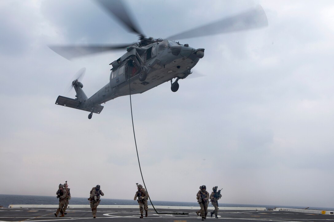 U.S. Marines fast rope from an MH-60s Seahawk helicopter to the flight ...