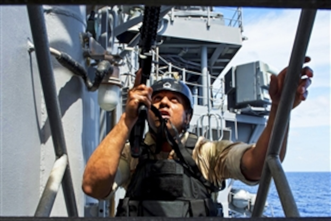A U.S. sailor assigned to the USS Shiloh's visit, board, search and seizure team climbs a ladder during boarding training in the South China Sea, March 14, 2015. The Shiloh is on patrol in the 7th Fleet area of operation supporting security and stability in the Indo-Asia-Pacific region.