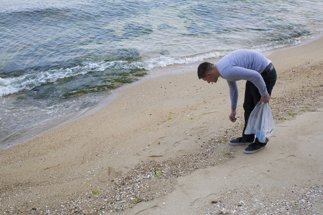 A service member with Marine Aviation Logistics Squadron 12 picks up trash at Tsuzu Beach during a community relations cleanup conducted by the Marine Aircraft Group Chaplain's Office abaord Marine Corps Air Station Iwakuni, Japan, March 13, 2014. Community relations events serve as an important tool in strengthening the bond between the U.S. and Japan. Major entities aboard station that conduct regular community relations events include the Marine Memorial Chapel, MAG-12 Chaplain's Office and the Single Marine Program.