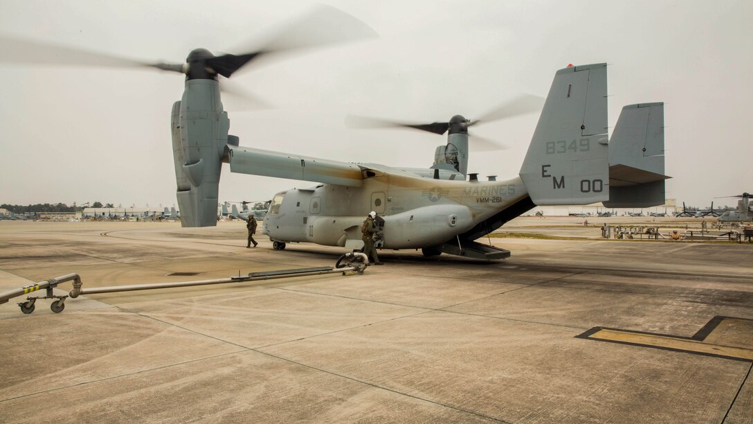 A crew chief with Marine Medium Tiltrotor Squadron 261 fuels an MV-22B Osprey while another inspects the aircraft prior to take-off aboard Marine Corps Air Station New River, N.C., March 3, 2015. Crew chiefs are essential to Osprey pilots, as they can see areas the pilot cannot and can make adjustments to components while in flight. 