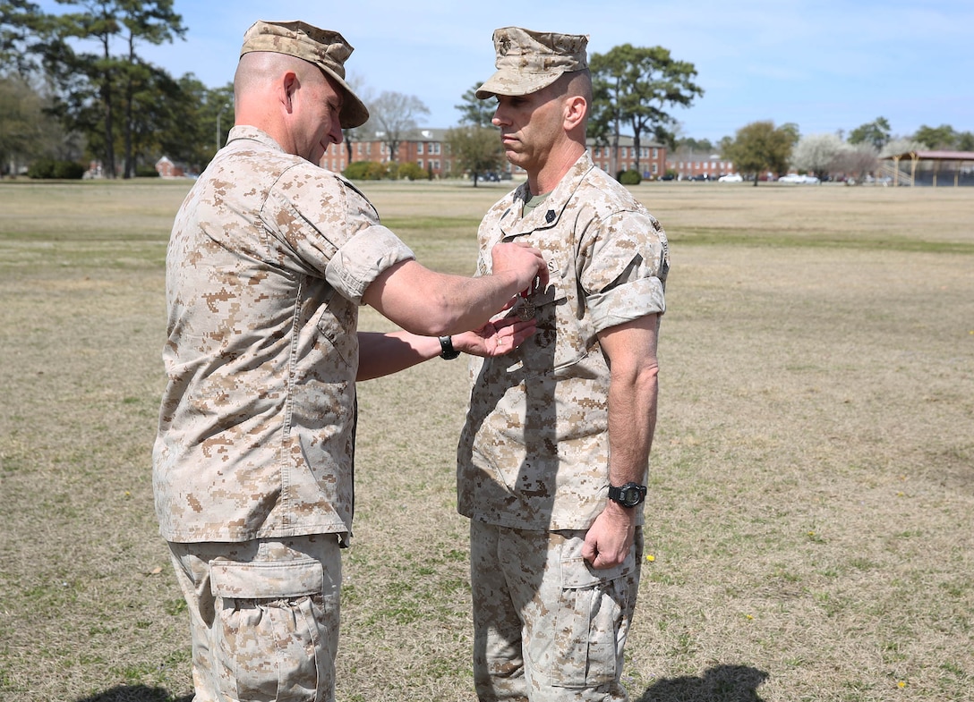 U.S. Marine Corps Col. William Dunn, left, 22nd Marine Expeditionary Unit (MEU) commanding officer, awards a Meritorious Service Medal to Master Sgt. Lon Stedman, a native of Los Angeles, for his service as the 22nd MEU communications chief at Marine Corps Base Camp Lejeune, N.C., March 16, 2015. (U.S. Marine Corps photo by Cpl. Caleb McDonald/Released)