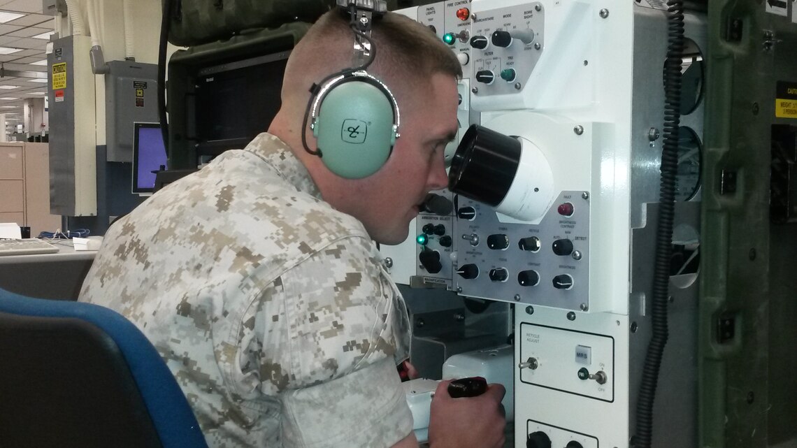 1st Lt. M. Joel Wagaman, project manager at Marine Corps Systems Command’s Program Manager Training Systems, demonstrates the use of the Advanced Gunnery Training System—a simulation-based system that provides Marine crews gunnery and tactical training for the M1A1 Main Battle Tank and Light Armored Vehicle. A team from PM TRASYS recently released the results of a study that prove training in the AGTS can increase Marines’ proficiency while costing the Corps millions less than live training.