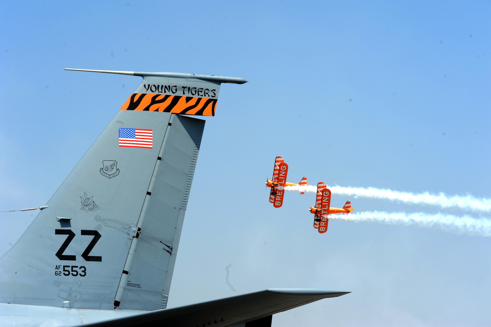 The U.K. stunt team, Breitling Wingwalkers, fly over a KC-135 Stratotanker during Aero India15, Feb. 19, 2015, at Air Force Station Yelahanka in Bengaluru, India. The KC-135 is from the 909th Air Refueling Squadron at Kadena Air Base, Japan. Aero India is India's premier aerospace exhibition and airshow and allowed the U.S. to demonstrate its commitment to the security of the Indo-Asia-Pacific region and showcase defense aircraft and equipment, which ultimately contributes toward better regional cooperation and tactical compatibility with other countries. This year marks the 10th iteration of Aero India since its inception in 1996. (U.S. Air Force photo/Airman 1st Class Stephen G.Eigel)