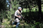 A North Dakota Soldier runs out from hiding to “ambush” a 191st Military Police Company convoy while serving as the opposing forces team during Golden Coyote, a military training exercise hosted by the South Dakota National Guard.