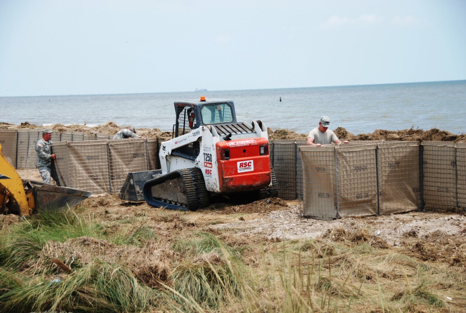 The Louisiana National Guard’s 225th Engineer Brigade construct a wall of sand-filled Hesco Concertainer units in Cameron, La., to help keep oil-tainted water in the Gulf of Mexico from moving inland, June 22 2010.