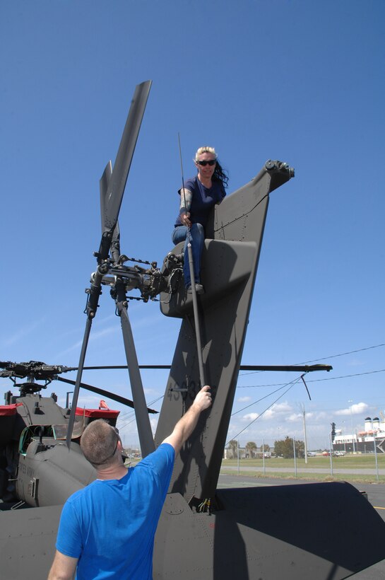 Elizabeth Bougher, aircraft mechanic, Lockheed Martin, removes a whip antenna from an Apache helicopter and hands it to Jason Rabalais, mechanic, Lockheed Martin, at Blount Island Command, Jacksonville, Fla., March 10. The helicopter is from the 101st Combat Aviation Brigade, Fort Campbell, Ky., nicknamed the "Wings of Destiny."