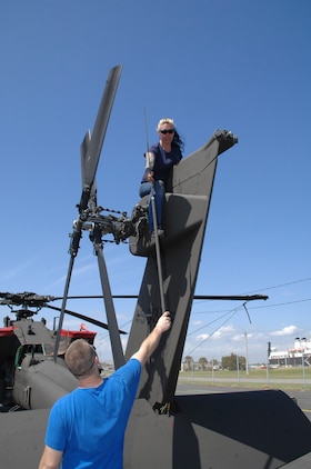 Elizabeth Bougher, aircraft mechanic, Lockheed Martin, removes a whip antenna from an Apache helicopter and hands it to Jason Rabalais, mechanic, Lockheed Martin, at Blount Island Command, Jacksonville, Fla., March 10. The helicopter is from the 101st Combat Aviation Brigade, Fort Campbell, Ky., nicknamed the "Wings of Destiny."