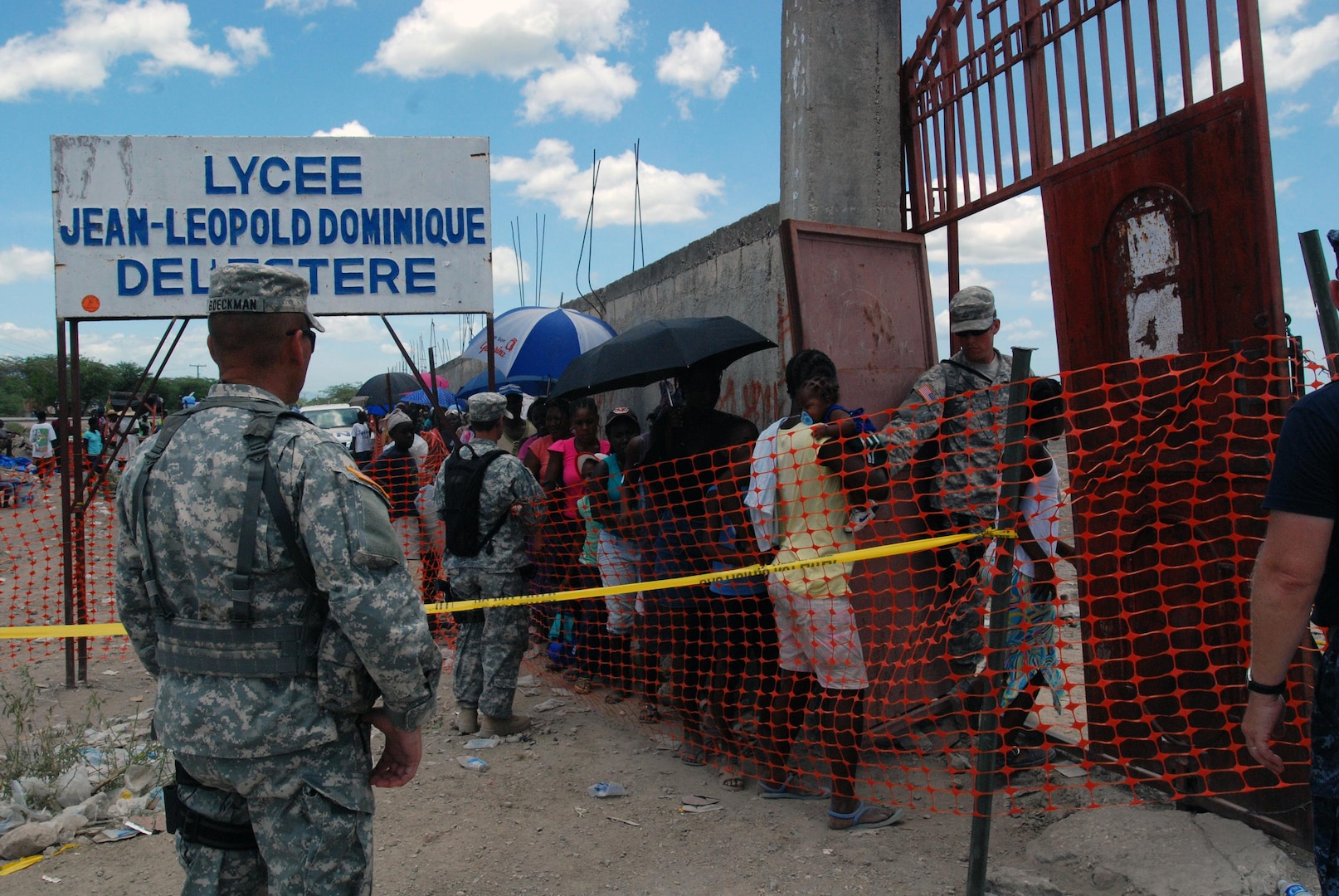 Nevada National Guard military police Sgt. 1st Class Damien Boeckman, Spc. Jacquelyn N. Eveatt and Pfc. Myles L. Foutz of the 485th Military Police Company make sure the people of Haiti safely enter the L’Etere Medical Assistance site June 19.