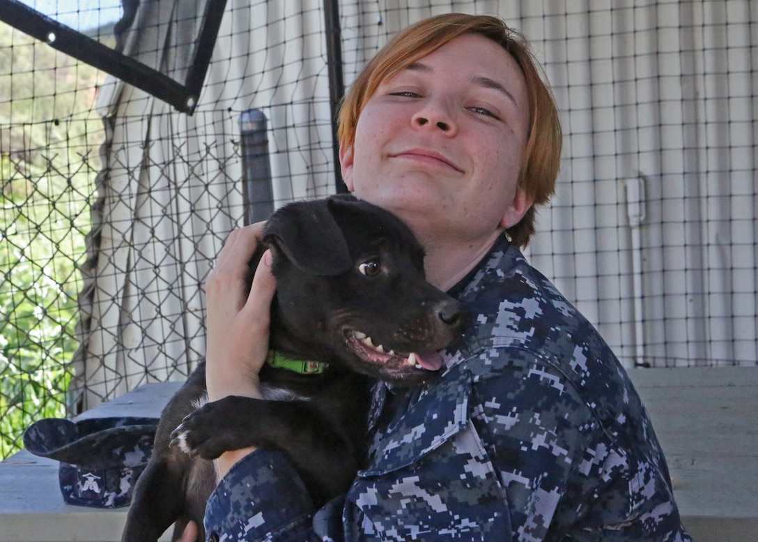 Petty Officer 3rd Class Mary Miller adopts a puppy during the St. Patrick’s Day Lucky Adoption Event, March 14 at the Camp Pendleton Animal Shelter. With events like the St. Patrick’s Day Lucky Adoption Event, the base shelter hopes to promote pet adoption by reducing normal adoption fees from $110 for dogs and $85 for cats to a cheaper amount which the adopters randomly draw from a hat. The fees are inclusive of neutering, a rabies vaccine, tracking microchip, a distemper vaccine and flea control.