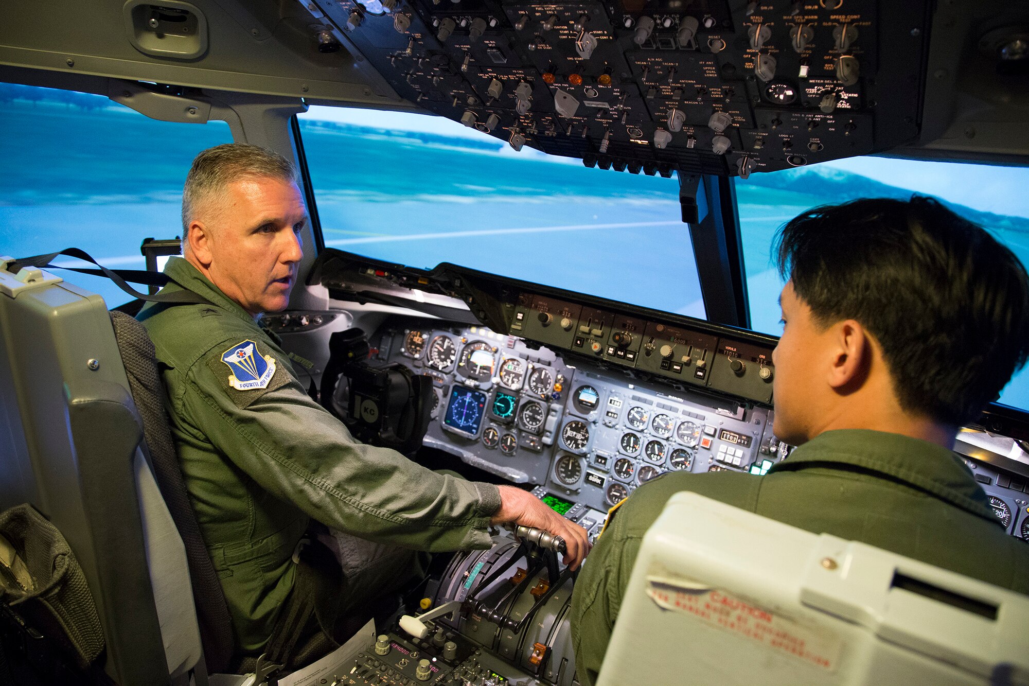 Brig. Gen. John. C. Flournoy, Jr. (left), Commander, 4th Air Force, speaks with Capt. Ray Kui, instructor pilot with the 79th Air Refueling Squadron, during KC-10A Extender simulator training March 16, 2015 at Travis Air Force Base, Calif. (U.S. Air Force photo/Lt. Col. Robert Couse-Baker/Released) 
