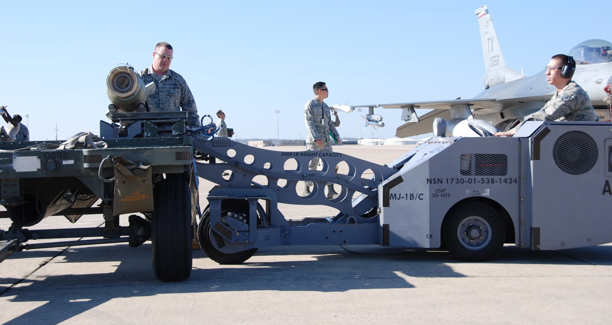 NAVAL AIR STATION FORT WORTH JOINT RESERVE BASE, Texas - Airmen from the 301st Aircraft Maintenance Unit here, pick up a weapon from the trailer to load on the aircraft Feb. 8 during the weapons load competition. Working side-by-side, active duty and Reserve Airmen towed, placed, and properly loaded four inert munitions onto each of the four F-16s in under 47 minutes. Three inspectors evaluated a crew on general knowledge test and munitions load. (U.S. Air Force photo/Staff Sgt. Melissa Harvey)